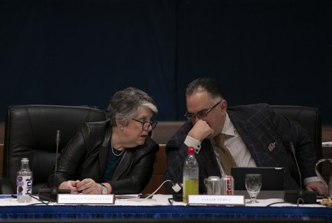 A woman with nameplate President Napolitano and a man with nameplate Chair Perez at a meeting.