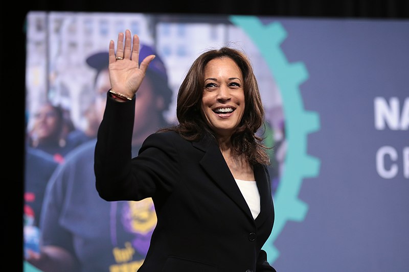 Kamala Harris smiling and waving.