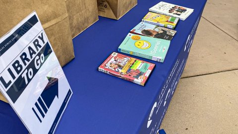 Table with books and library to-go sign