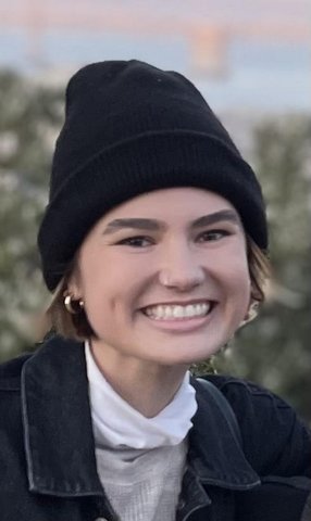 A smiling young woman in a beanie.
