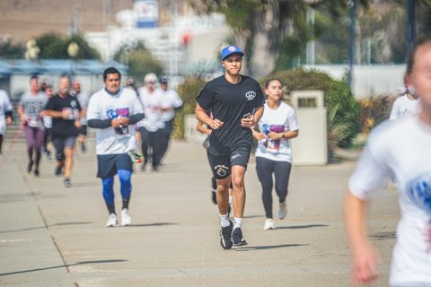 Various people running with one young man in sharper focus than the rest