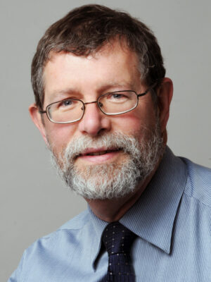 White man with glasses, beard, blue shirt and tie