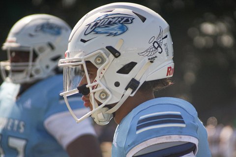 Football player wearing a white helmet that features the no. 9 with angel wings.