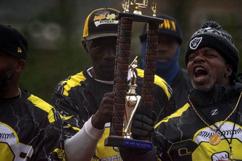 A group of Black men holding up a trophy