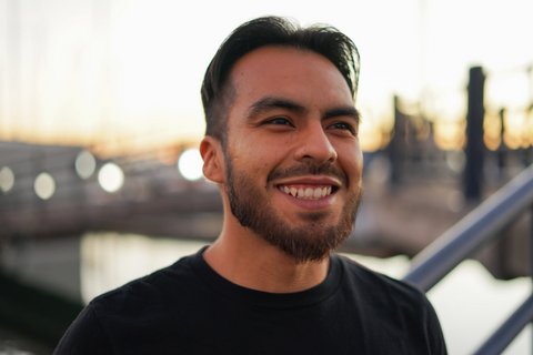 A smiling Latino man with short hair and a beard