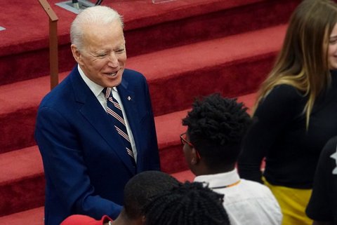 Joe Biden shaking a Black person's hand among a crowd
