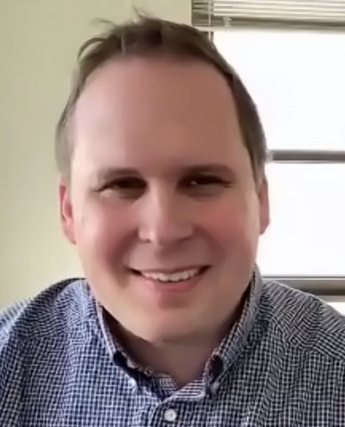 Smiling white man with short hair and blue button-down shirt