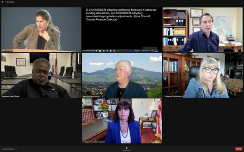 Screenshot from virtual meeting showing six people and slide that says "consider adopting additional Measure X sales tax funding allocations, and consider adopting associated appropriation adjustments. (Lisa Driscoll, County Finance Department)"