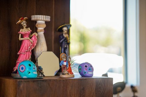 Figurines of skeletons in traditional Mexican clothing and colorfully painted skulls