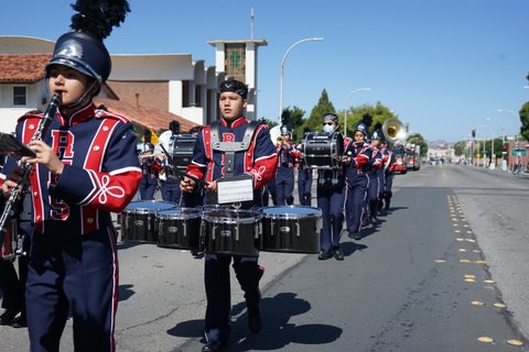 A high school marching band going down a city street in a parade