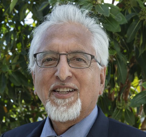 Latino man with white hair, goatee and glasses