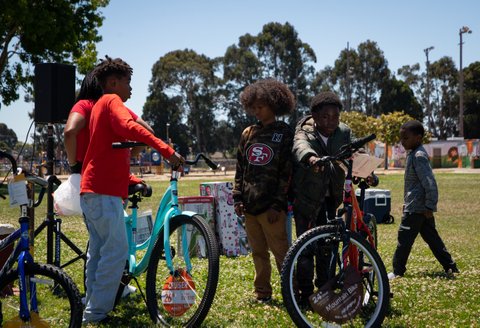 Black children looking at bicycles in a park
