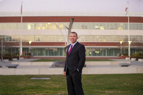 Man in a suit with Richmond City Hall in the background