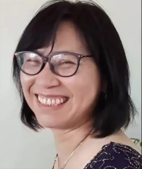 A smiling Asian woman wearing glasses