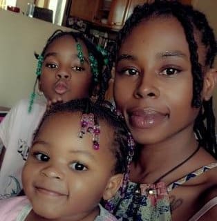 A young Black woman and her two young daughters