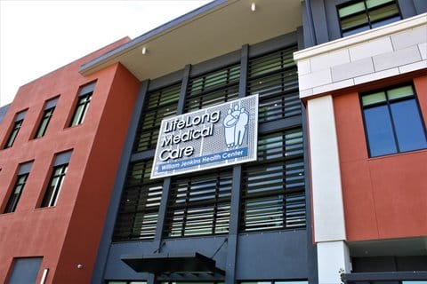 Front of a multi-story building with large sign that says LifeLong Medical Care William Jenkins Health Center