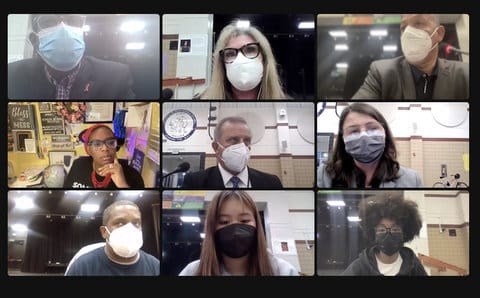 Screenshot of nine people in a virtual meeting. Eight of them are wearing masks.
