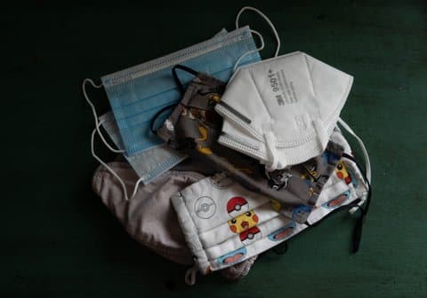 A pile of masks, including N95s made by 3M and one decorated with Pokémon designs