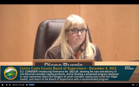 Blonde woman politician and text that reads Contra Costa Board of Supervisors December 6, 2022. Consider introducing Ordinance No. 2022-28, allowing the sale and delivery of non-flavored cannabis vaping products, and to develop a proposed program designed to raise awareness about the dangers of youth cannabis vaping and curtail the illegal market, and return to the Board of Supervisors with a recommended program.