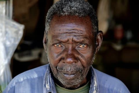 An older Black man looking directly at the camera