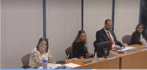 Three women and one man in a government meeting