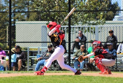 High school baseball player following through on a swing