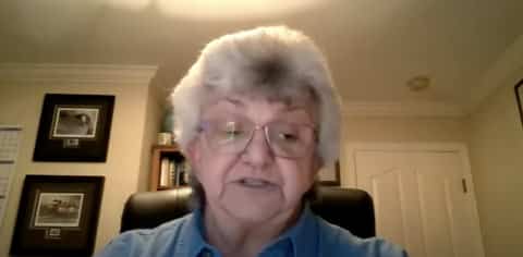 An older white woman in a home office-type setting on a Zoom call