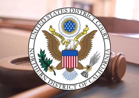 Seal for the United States District Court Northern District of California superimposed over a photo of a gavel on a judge's bench.