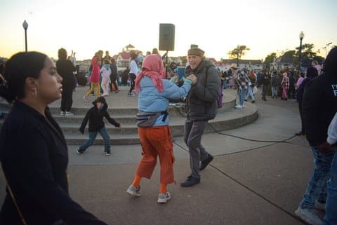 An older man and a woman dancing among a crowd