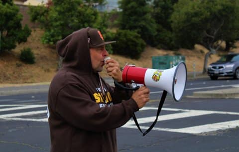 A white man speaks into a megaphone