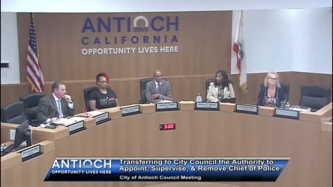 Antioch City Council members in a meeting. From left to right, they are a white man, black woman, black man, black woman and white woman. Name plates show they are Mike Barbanica, Tamisha Torres Walker, Lamar Thorpe, Monica Wilson and Lori Ogorchok. Lettering on the wall behind them says Antioch opportunity lives here. On screen text says transferring to city council the authority to appoint, supervise and remove chief of police