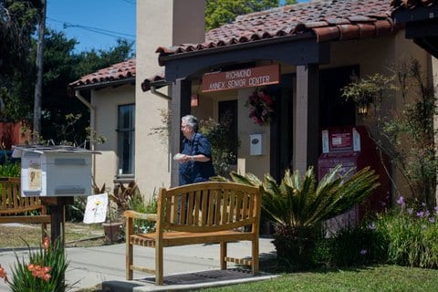 An older white person walking out of the Richmond Annex Senior Center