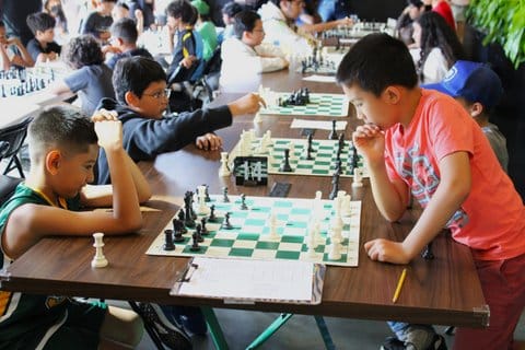 Two young chess players mull over their next move
