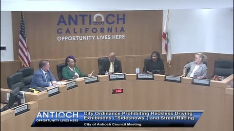 Screenshot of Antioch City Council meeting showing the members with onscreen text that reads "city ordinance prohibiting reckless driving exhibitions ('sideshows') and street racing"