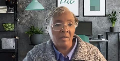 A Black woman with gray hair speaking in a Zoom meeting