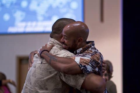 Two black men embraced in hug